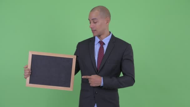 Šťastný holohlavý multietnický obchodník držící tabuli a zvedá palce — Stock video