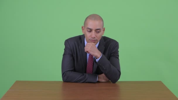 机の後ろで考えるストレスハゲ多民族ビジネスマン — ストック動画