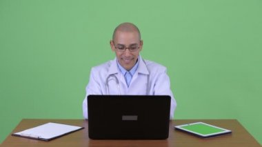 Mutlu kel çok etnik adam doktor iş yerinde telefonda konuşurken