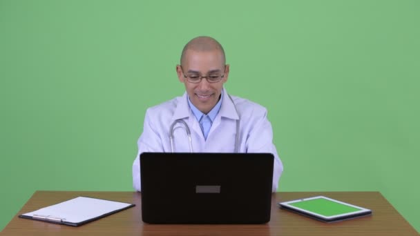 Boldog kopasz többnemzetiségű ember orvos beszél a telefonon munkában — Stock videók