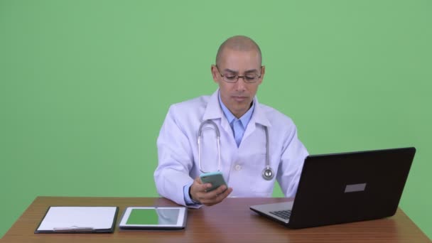 Щасливий лисий мульти етнічний чоловік лікар відео дзвінок на роботі — стокове відео