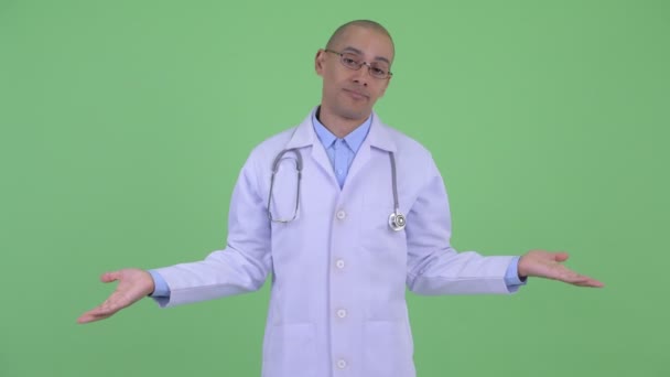 Confuso calvo multi étnico hombre médico encogiéndose de hombros — Vídeos de Stock