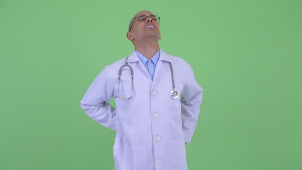 Stressed bald multi ethnic man doctor having back pain — Stock Video