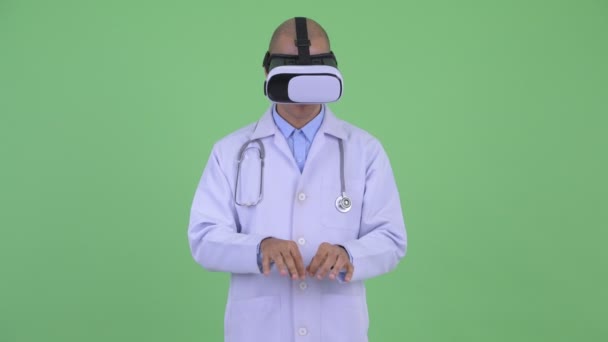 Guapo calvo multiétnico médico hombre usando auriculares de realidad virtual — Vídeo de stock