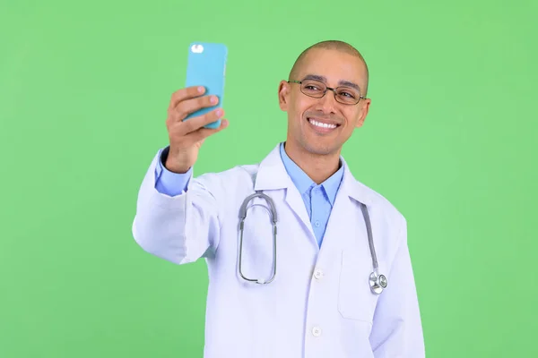 Szczęśliwy łysy wielu etnicznych człowiek lekarz rozmowy wideo z telefonem — Zdjęcie stockowe