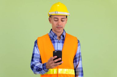 Yakışıklı çok etnik adam inşaat işçisi telefon kullanarak