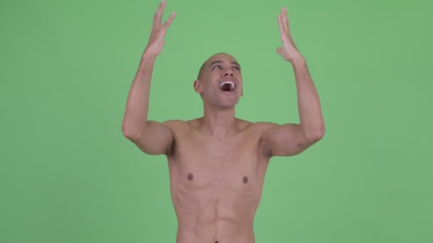Счастливый лысый многонациональный мужчина без рубашки ловит что-то — стоковое видео