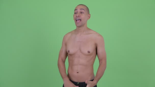 Счастливый лысый многонациональный мужчина без рубашки vlogging и говорить с камерой — стоковое видео