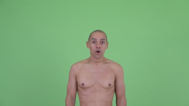 Лицо счастливого лысого мужчины без рубашки выглядит удивлённым — стоковое видео