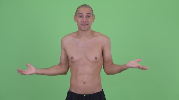 Confused bald multi ethnic shirtless man shrugging shoulders — Stock Video