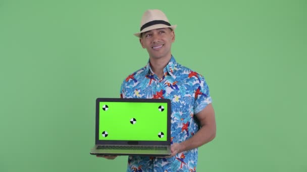 Feliz multi étnico turista homem pensando ao mostrar laptop — Vídeo de Stock