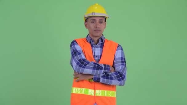 Щасливий багатонаціональний працівник будівництва посміхається з схрещеними руками — стокове відео