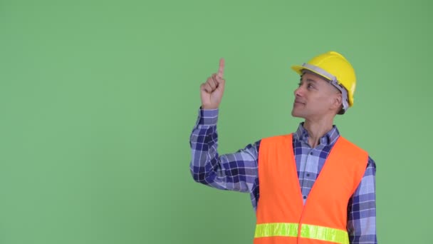 Happy multi ethnic man construction worker talking while pointing up — Stock Video