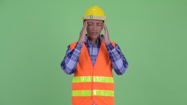 Stressed multi ethnic man construction worker having headache — Stock Video