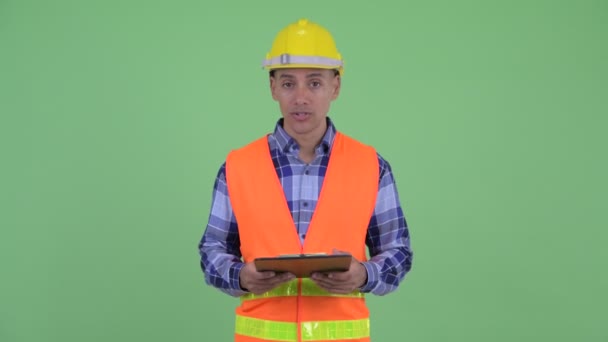 Heureux homme multi ethnique travailleur de la construction parler tout en tenant presse-papiers — Video