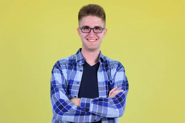 Feliz jovem hipster bonito homem sorrindo com os braços cruzados — Fotografia de Stock