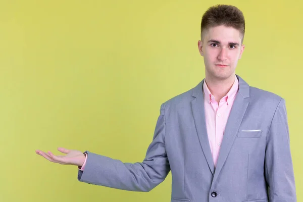 Portrait of young handsome businessman showing something — Stock Photo, Image