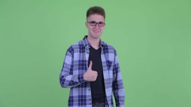 Счастливый молодой симпатичный хипстер, показывающий большие пальцы — стоковое видео