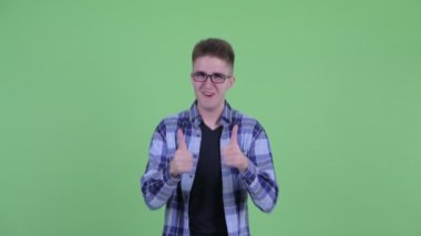 Mutlu genç yakışıklı hipster adam başparmak veren ve heyecanlı görünümlü