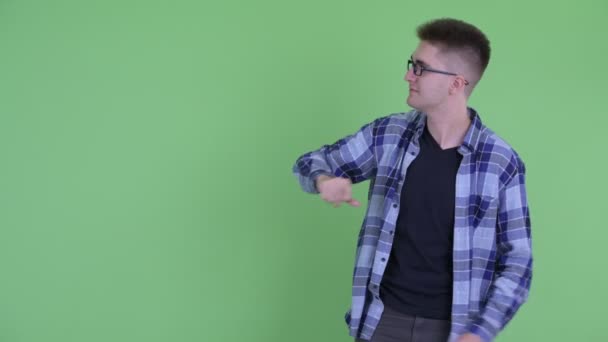 Gelukkig jonge hipster man wijzende vingers en iets te laten zien — Stockvideo