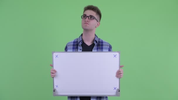Ευτυχισμένος νέος χίπστερ άνθρωπος σκέφτεται ενώ κρατώντας λευκή σανίδα — Αρχείο Βίντεο