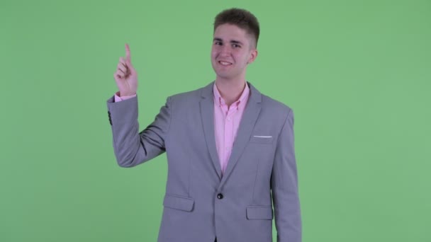 Счастливый молодой бизнесмен указывает на — стоковое видео