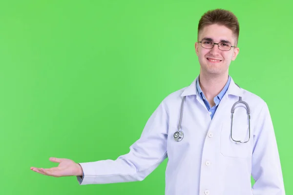 Jovem feliz bonito homem médico mostrando algo — Fotografia de Stock