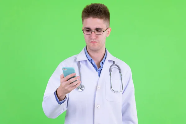 Jovem médico homem bonito com óculos usando telefone — Fotografia de Stock