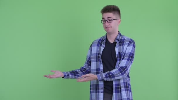 Stresli genç hipster adam bir şey gösteren — Stok video