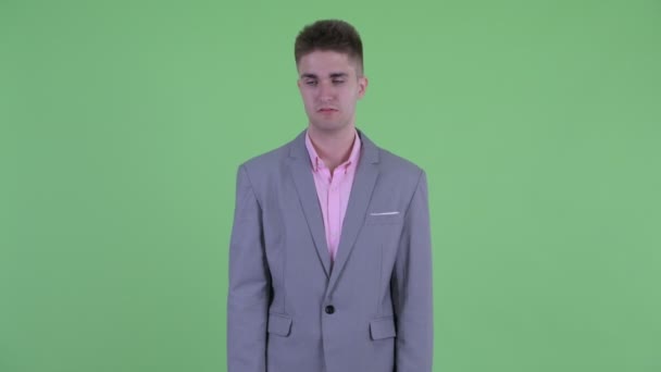 Gestresster junger Geschäftsmann sieht gelangweilt und müde aus — Stockvideo