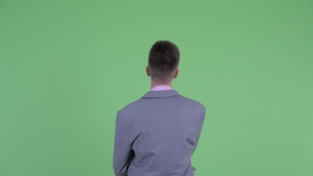 Вид спереду молодого бізнесмена, який вказує пальцем — стокове відео