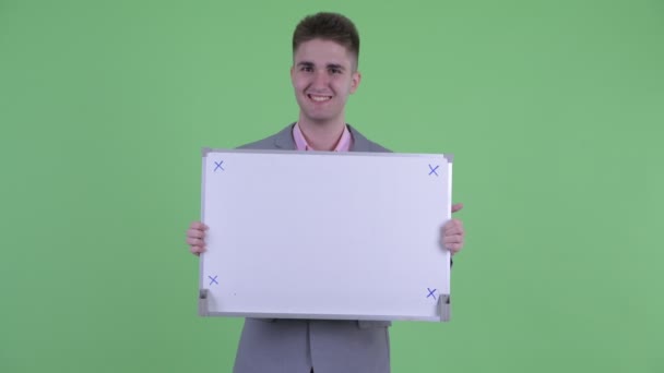 Gelukkig jonge zakenman denken terwijl het houden van Whiteboard — Stockvideo