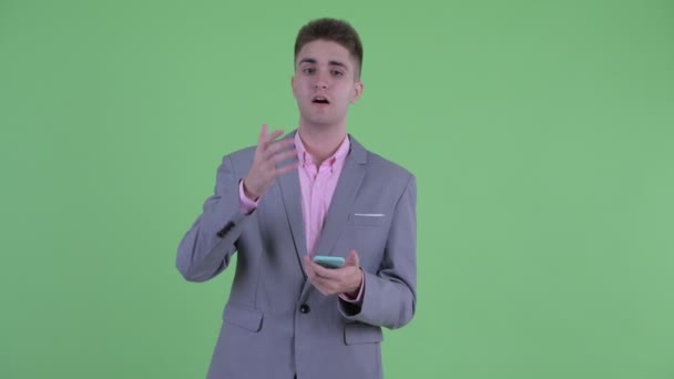 Jovem empresário estressado usando telefone e recebendo más notícias — Vídeo de Stock