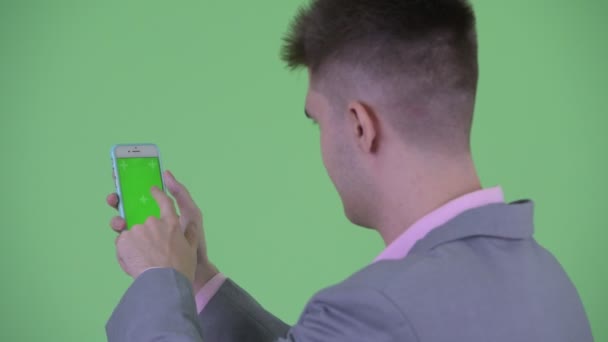 Closeup bakbillede af unge forretningsmand ved hjælp af telefon – Stock-video