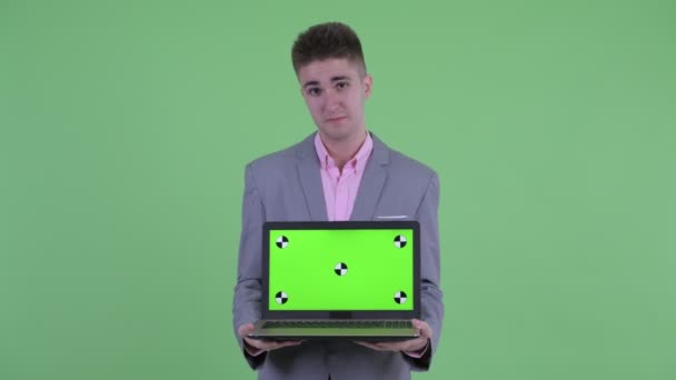 Lycklig ung affärsman pratar när du visar laptop — Stockvideo