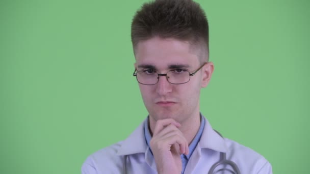 Gezicht van beklemtoonde jonge man Doctor denken en naar beneden kijken — Stockvideo
