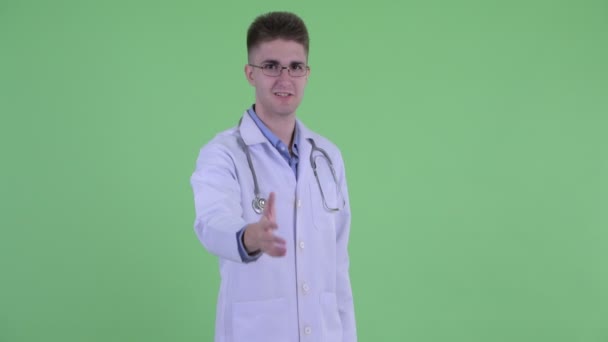 Happy young man doctor giving handshake — Stock Video