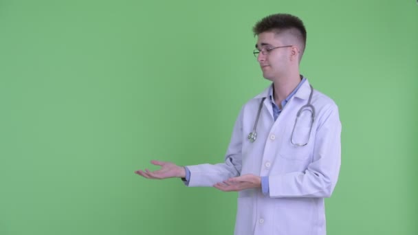 Наголошений молодий чоловік лікар щось показує — стокове відео