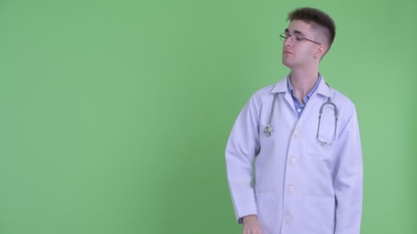 Jovem médico feliz tocando algo e dando polegares para cima — Vídeo de Stock