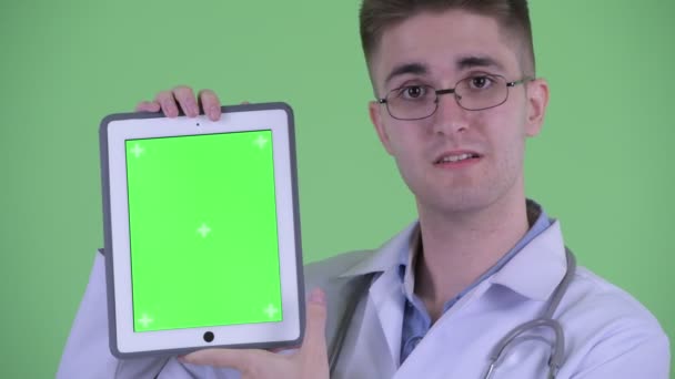 Rosto de jovem feliz médico mostrando tablet digital — Vídeo de Stock