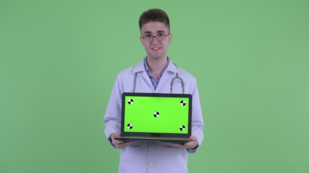 Felice giovane medico parlando mentre mostra il computer portatile — Video Stock