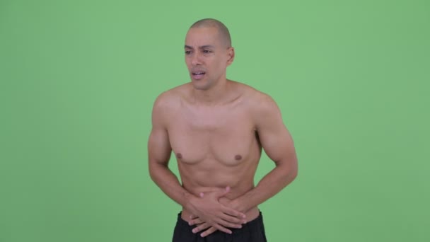 Stressed bald multi ethnic shirtless man having stomachache — Stock Video