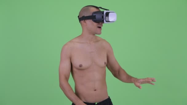 Happy bald multi ethnic shirtless man using virtual reality headset — Stock Video