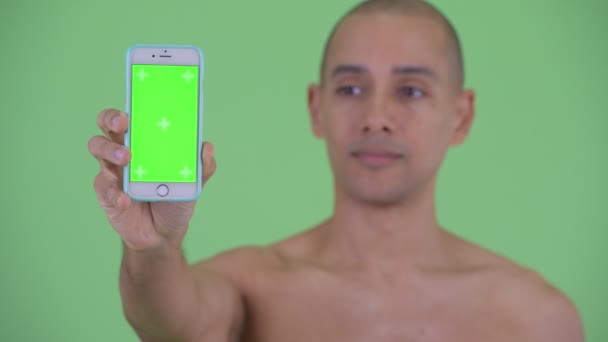 Cara de feliz calvo multi étnico sin camisa hombre mostrando el teléfono — Vídeo de stock