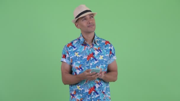 Feliz hombre turístico multiétnico pensando y usando el teléfono — Vídeos de Stock