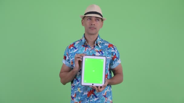 Feliz multi étnico turista homem pensando ao mostrar tablet digital — Vídeo de Stock