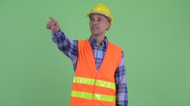 Mutlu çok etnik adam inşaat işçisi işaret parmak