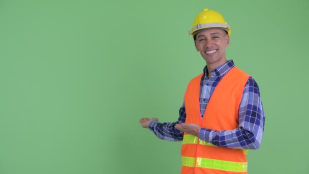 Feliz hombre multiétnico trabajador de la construcción mostrando a la espalda — Vídeo de stock