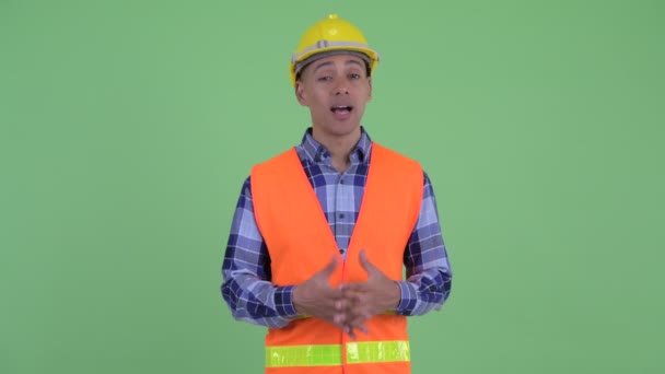 Щасливий багатонаціональний працівник будівництва, який щось пояснює — стокове відео