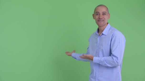 Feliz careca multi empresário étnico mostrando para trás e olhando surpreso — Vídeo de Stock